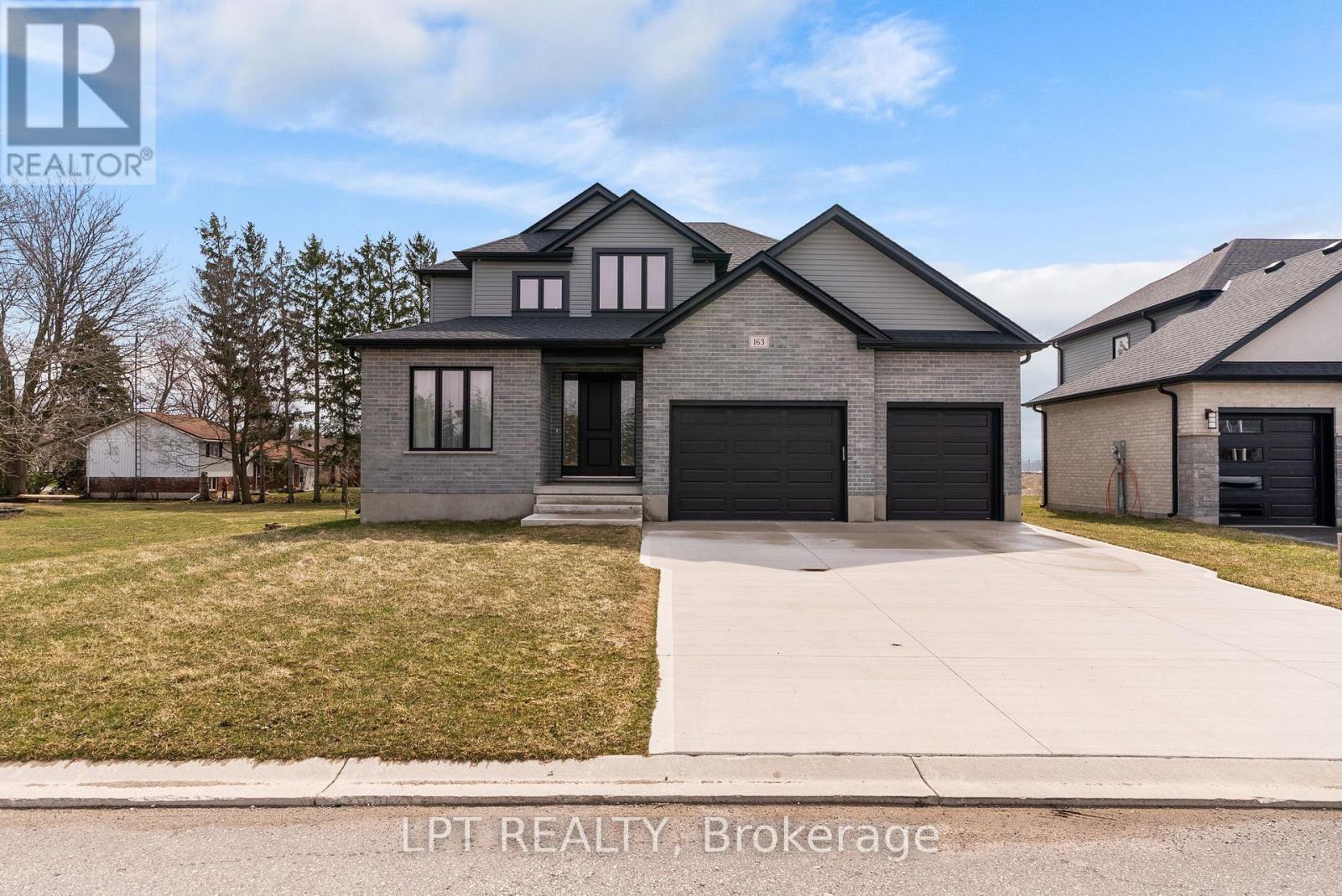 A modern house with a grey exterior and a black garage door.