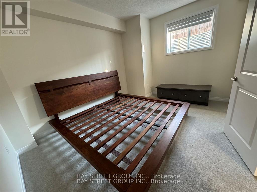 A bedroom with a wooden bed frame and a black dresser.