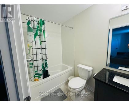 A small bathroom with a toilet, sink and shower.