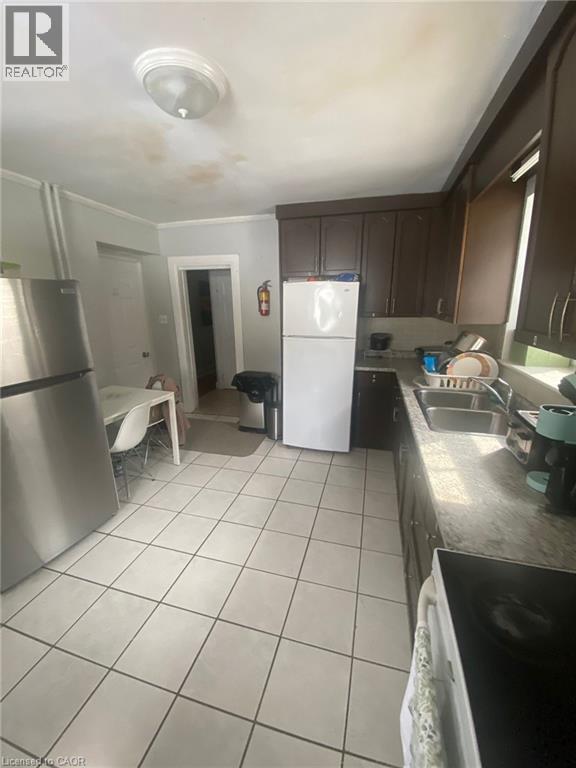 A kitchen with a white fridge and a stainless steel oven.