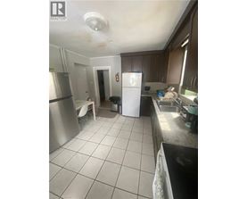 A kitchen with a white fridge and a stainless steel oven.