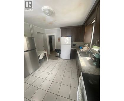 A kitchen with a white fridge and a stainless steel oven.