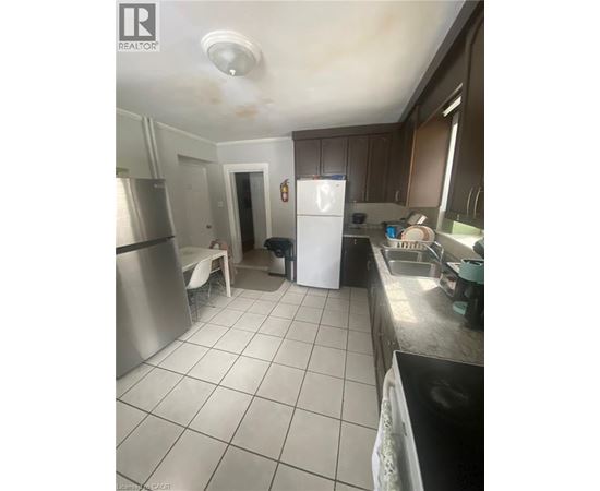 A kitchen with a white fridge and a stainless steel oven.
