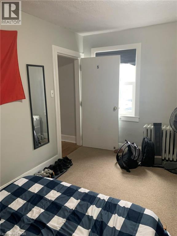 A bedroom with a bed covered in a blue and white checkered comforter.