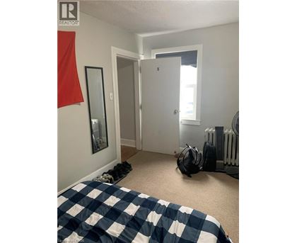 A bedroom with a bed covered in a blue and white checkered comforter.