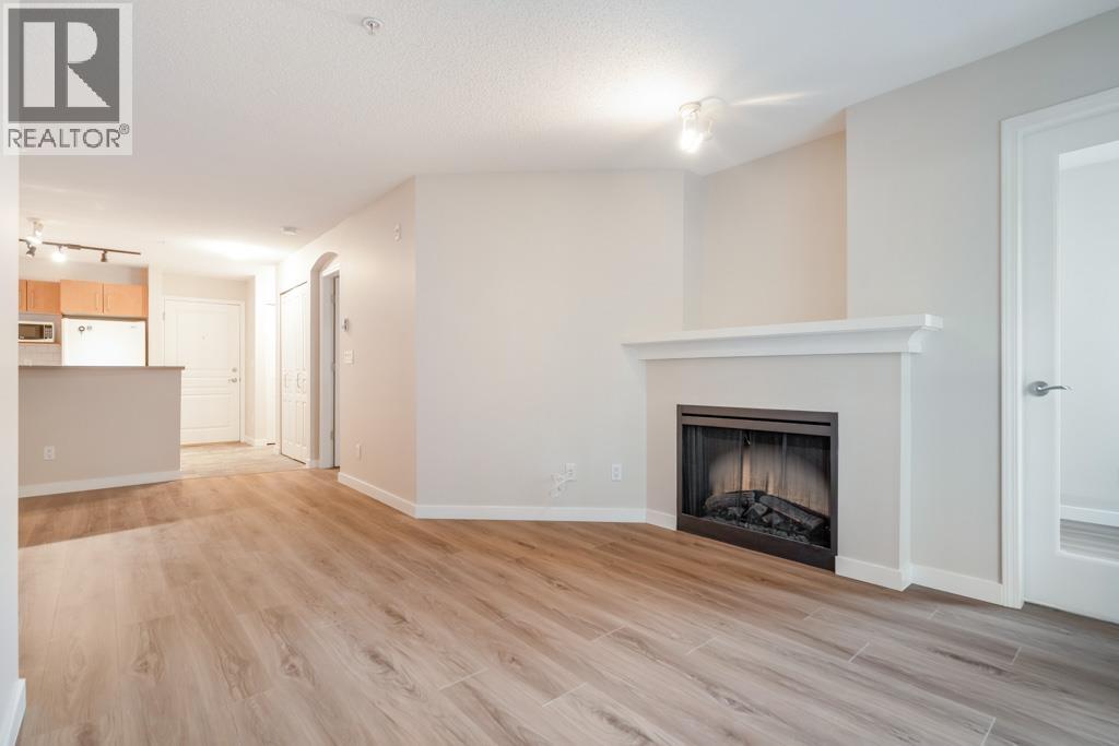 A spacious living room with a fireplace and hardwood floors.