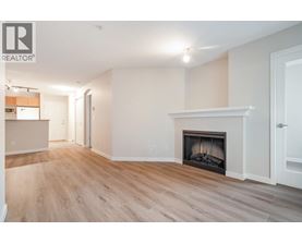 A spacious living room with a fireplace and hardwood floors.