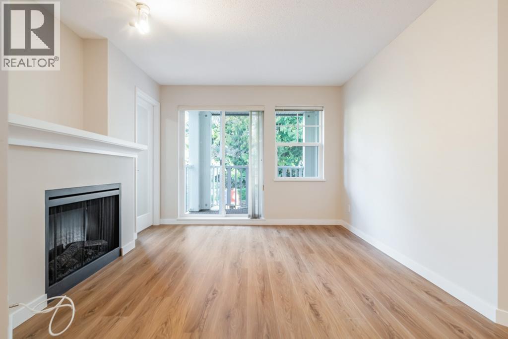 A spacious room with a fireplace and sliding glass doors leading to a balcony.