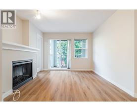 A spacious room with a fireplace and sliding glass doors leading to a balcony.