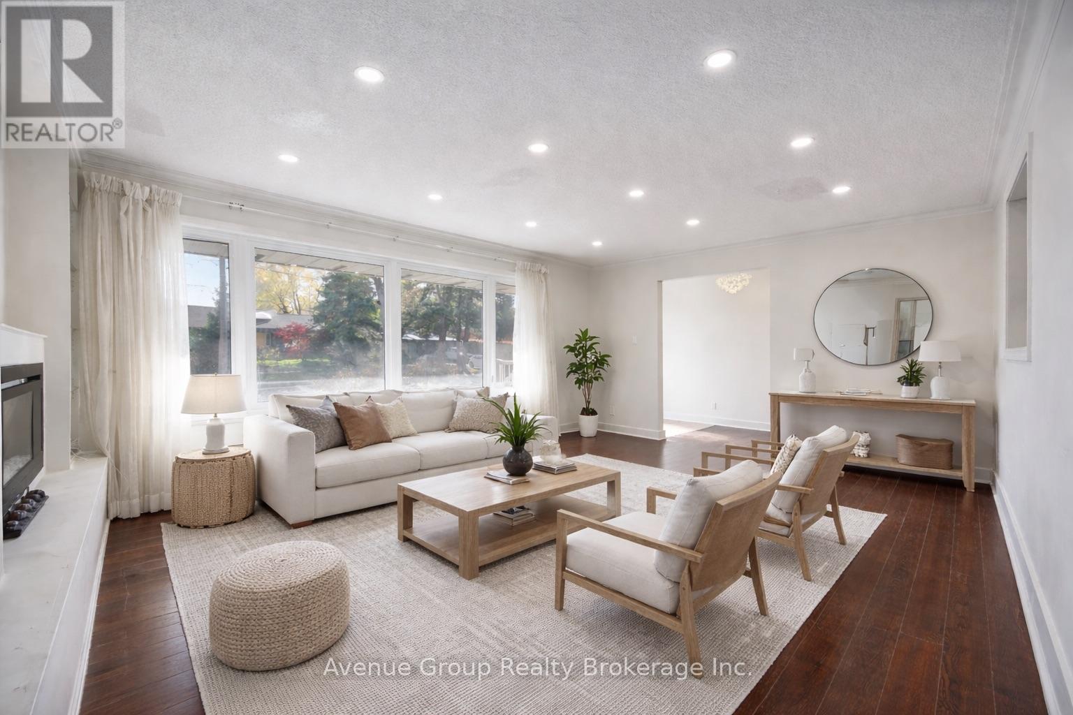 A well-lit living room with a large window, a sofa, a coffee table, and a television.