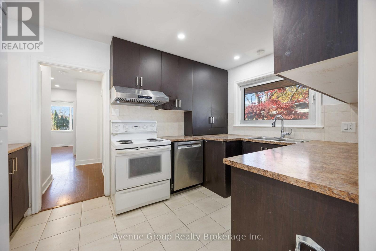 A kitchen with a white stove top oven and a white dishwasher.