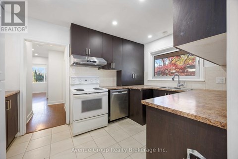 A kitchen with a white stove top oven and a white dishwasher.