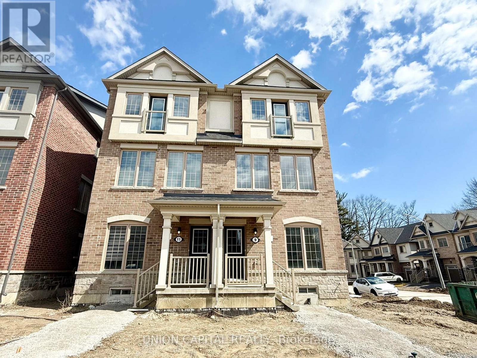 A house with a brick facade and a large front porch is for sale.