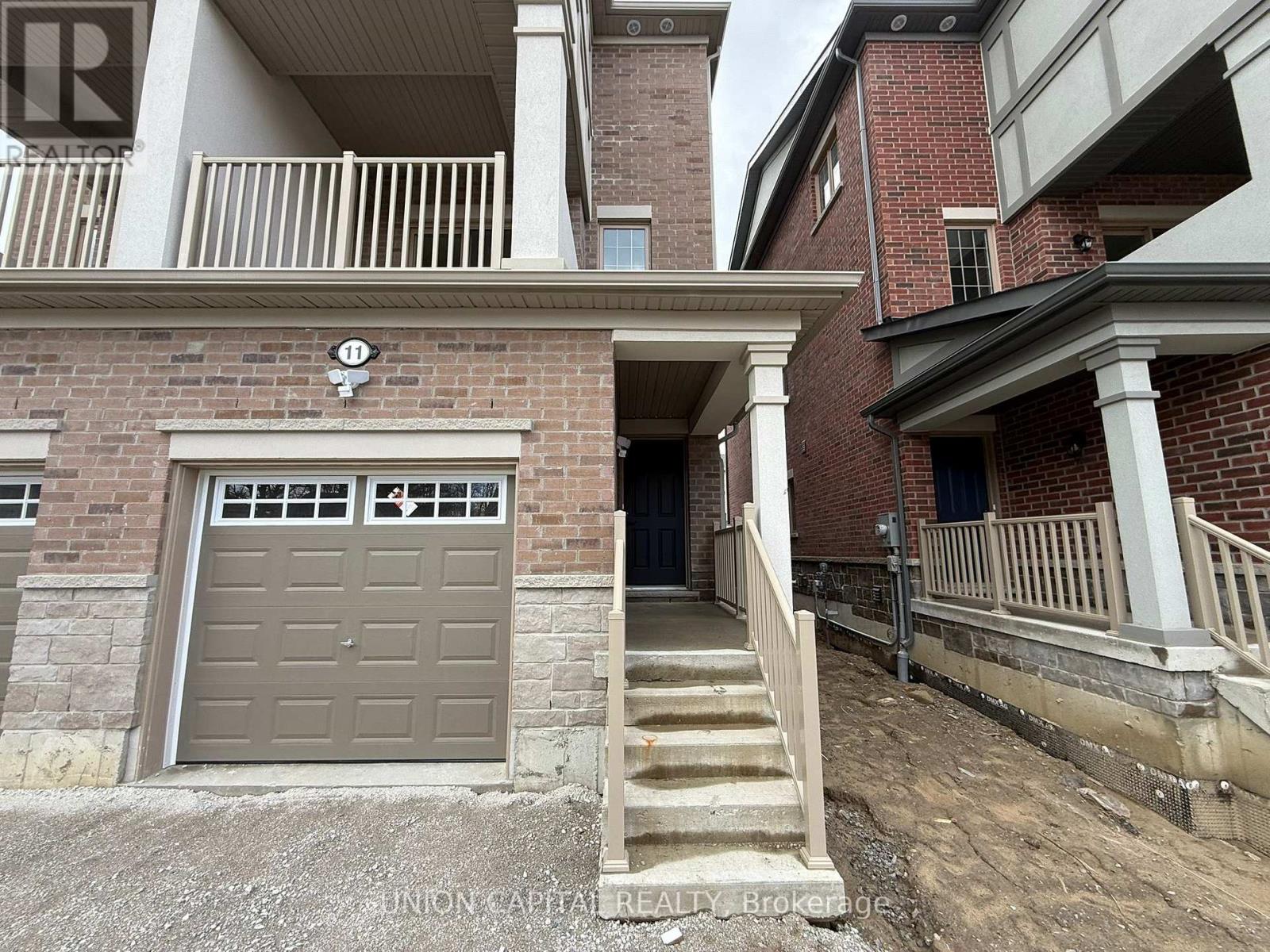 A building with a garage door and stairs leading to it.
