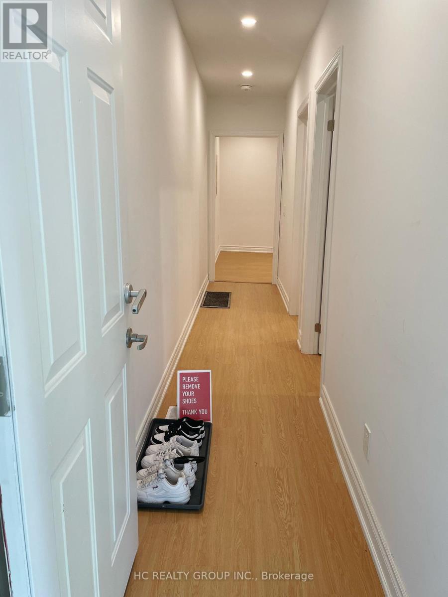 A brochure for a realtor is on the floor of a hallway.