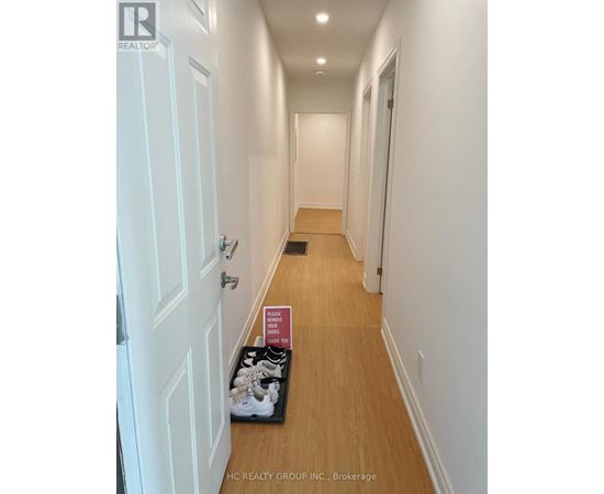 A brochure for a realtor is on the floor of a hallway.