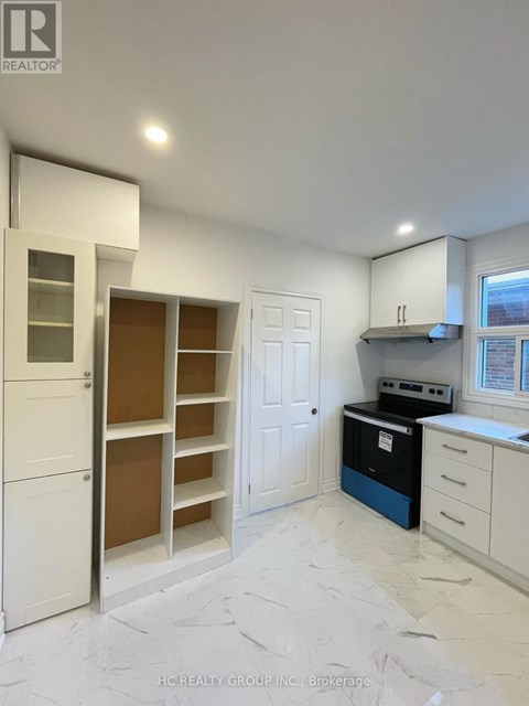 A kitchen with white cabinets and a blue dishwasher.