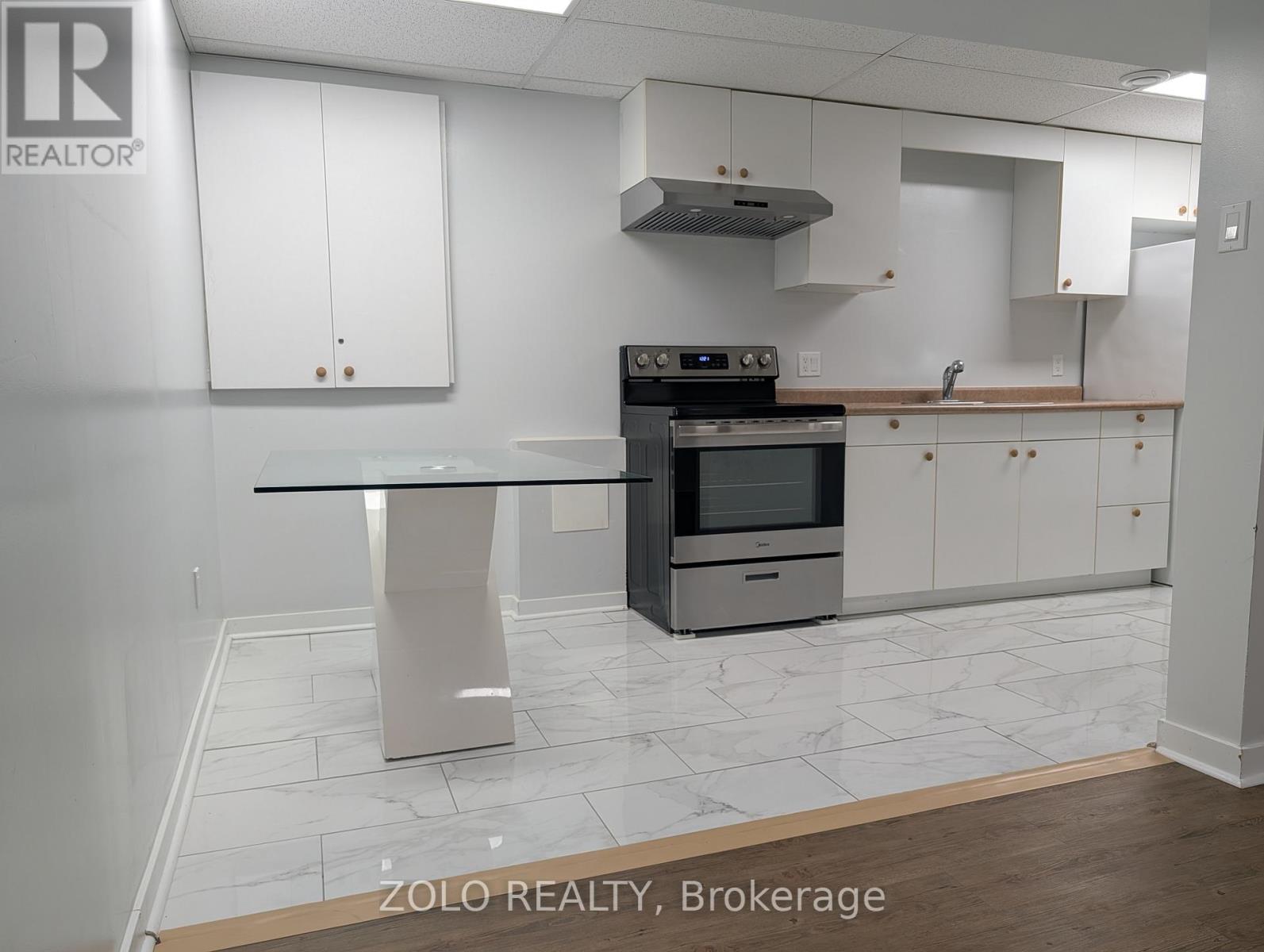 A kitchen with a stove top oven and a table.