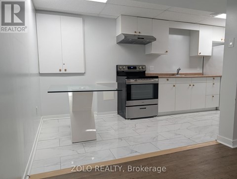 A kitchen with a stove top oven and a table.