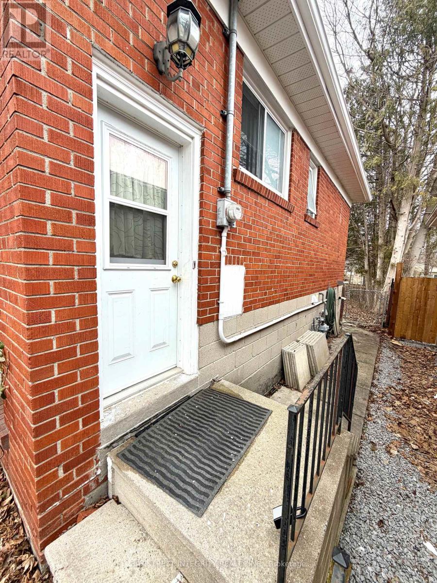 A red brick house with a white door and a black railing.