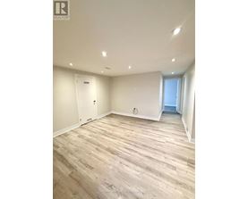 A room with wooden flooring and white walls.