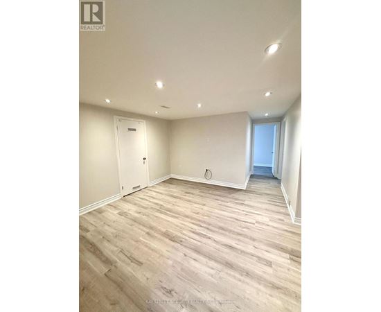 A room with wooden flooring and white walls.