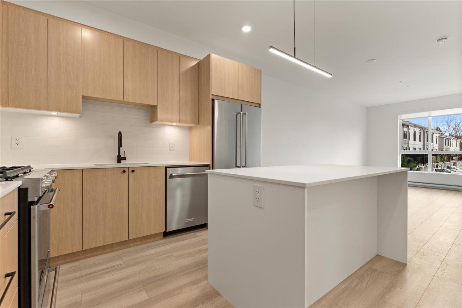 A modern kitchen with wooden cabinets and stainless steel appliances.