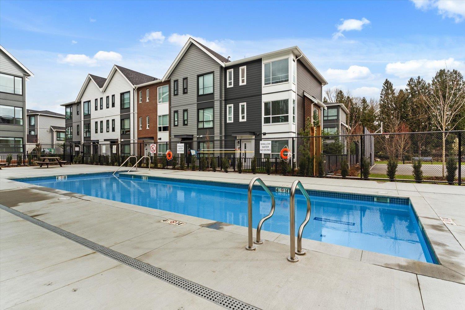 A swimming pool in front of apartment buildings.