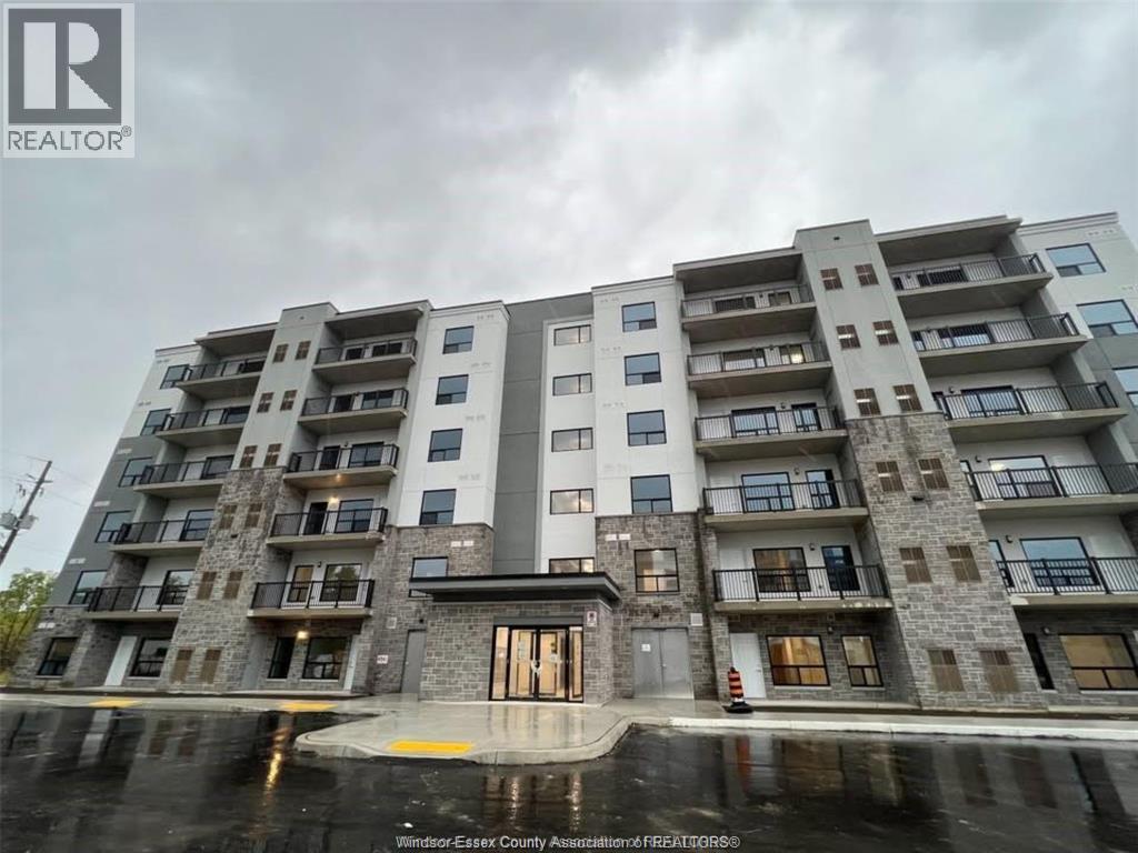 A large apartment building with a wet ground in front.