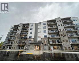 A large apartment building with a wet ground in front.