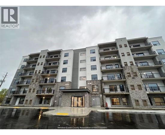 A large apartment building with a wet ground in front.
