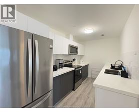 A modern kitchen with a stainless steel refrigerator and a microwave above the stove.