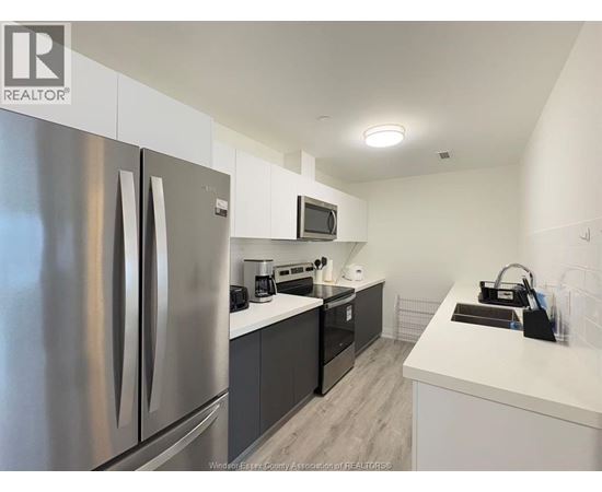 A modern kitchen with a stainless steel refrigerator and a microwave above the stove.