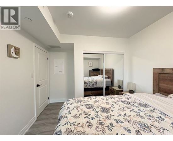 A bedroom with a large bed and a mirror on the wall.