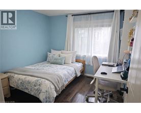 A bedroom with a bed, desk, and chair.