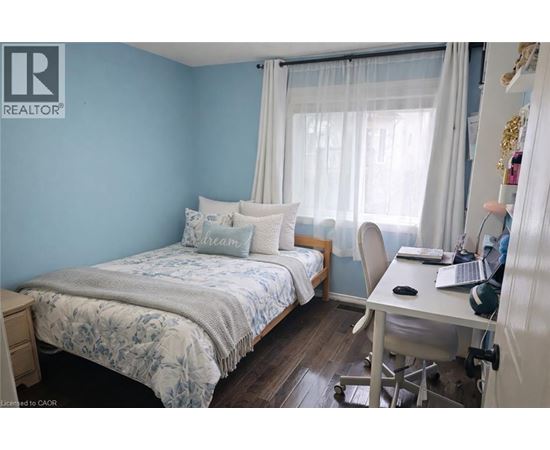 A bedroom with a bed, desk, and chair.