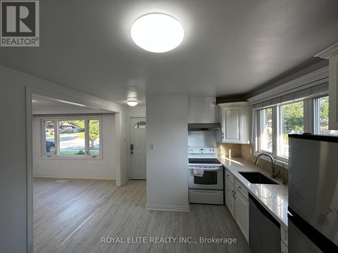 A kitchen with white cabinets and a stainless steel refrigerator.