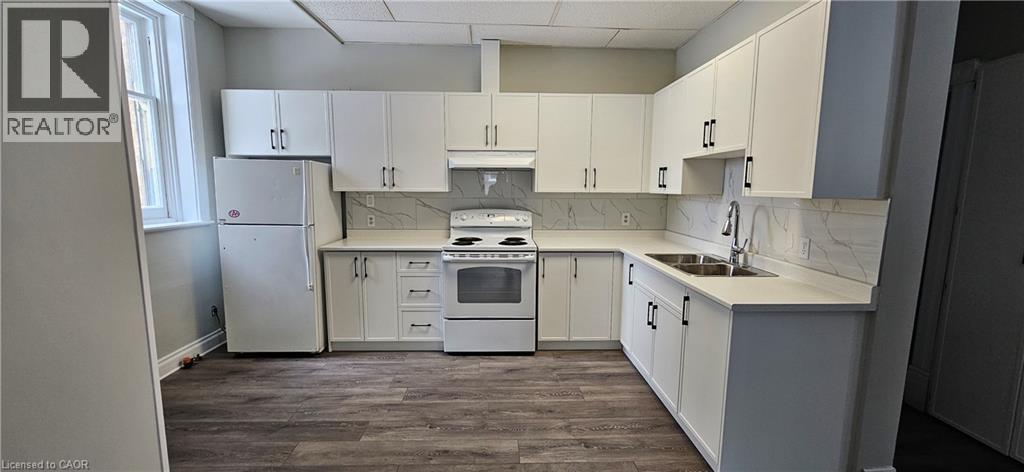 A kitchen with white cabinets and a marble countertop.