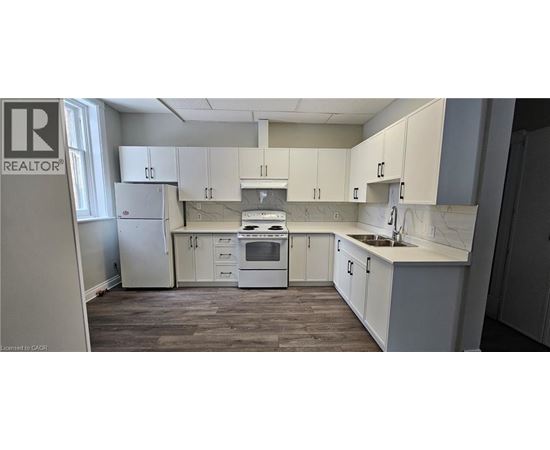 A kitchen with white cabinets and a marble countertop.