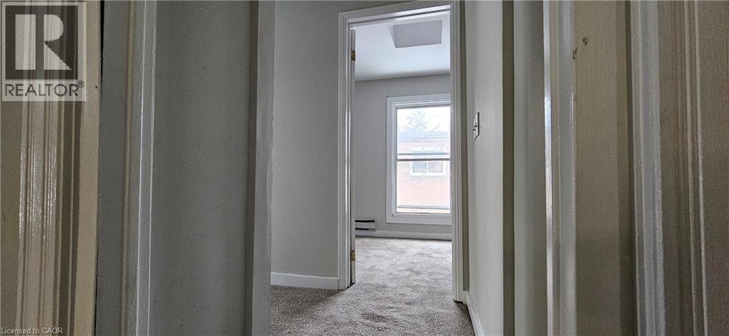 A realtor's office with a doorway leading to a bedroom.