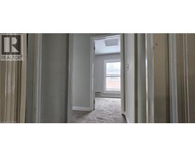A realtor's office with a doorway leading to a bedroom.