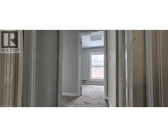 A realtor's office with a doorway leading to a bedroom.