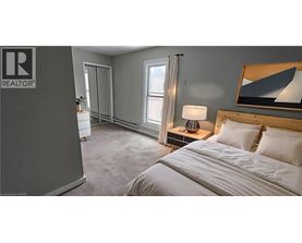 A bedroom with a bed, nightstand, and a painting on the wall.