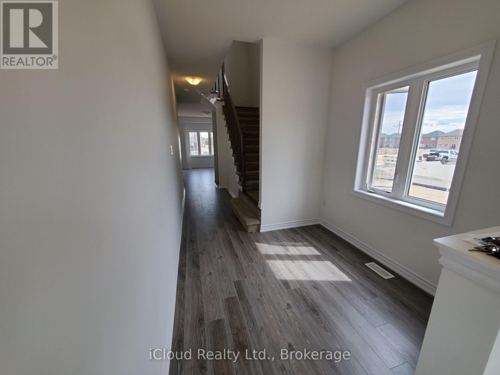 A hallway with wooden floors and white walls.