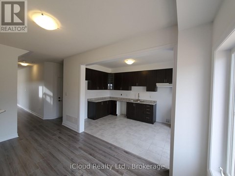 A well-lit kitchen area with a dining table and chairs is visible.