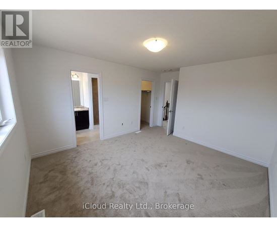 A spacious room with a carpeted floor and white walls.