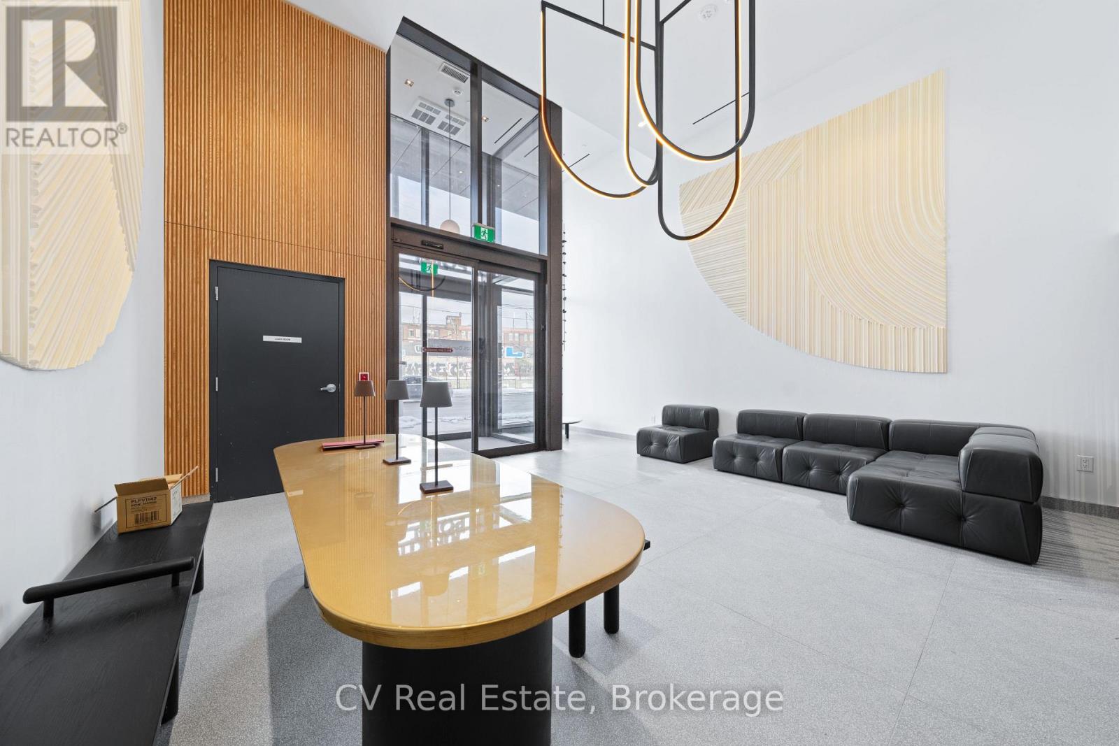 A modern office space with a wooden table and black leather chairs.
