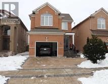 A house with a brown brick exterior and a garage door is shown.