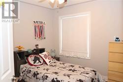 A bedroom with a bed, dresser and window.