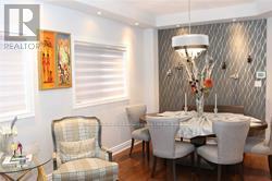 A dining room with a table set for two and a painting on the wall.